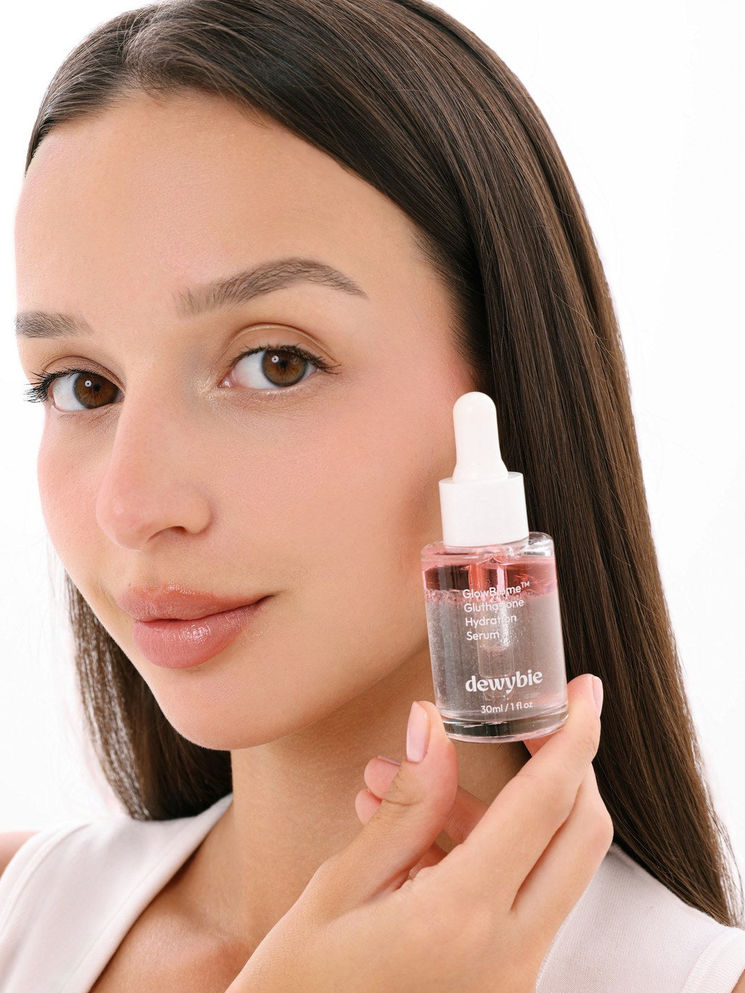 Model with dewy, glowing skin holding dewybie GlowBiome Glutathione Hydration Serum
