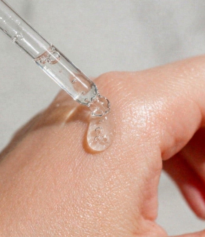 Applying dewybie hydration serum with a dropper for a dewy glow